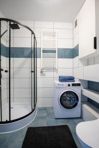 a washing machine in a bathroom with a shower at Vip Apartament Wieniawskiego in Rzeszów