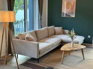 a living room with a couch and a table at Ferienwohnung-Parkplatz-Balkon-Küche-Aufzug-SmartTV-Waschtrockner in Erlangen