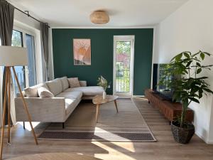 a living room with green walls and a couch at Bitetti#No.1 Balkon - Kostenloser Parkplatz - Waschtrockner - Küche in Erlangen
