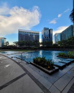 una piscina en medio de una ciudad con edificios altos en Uptown Parksuites Tower 1 BGC - Staycations Up Above 12 Modern 1BR en Manila