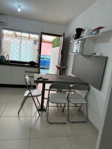a table and chairs in a kitchen with a window at Apartamento studio térreo in Balneário Camboriú