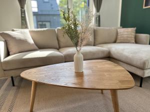 a vase on a coffee table in a living room at Ferienwohnung-Parkplatz-Balkon-Küche-Aufzug-SmartTV-Waschtrockner in Erlangen