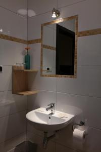 a bathroom with a sink and a mirror at Hotel Pod Chełmem in Ropa
