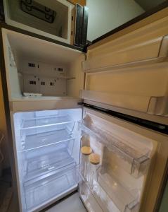 a refrigerator with its door open with its drawers at Uptown Parksuites Tower 1 BGC - Staycations Up Above 12 Modern 1BR in Manila