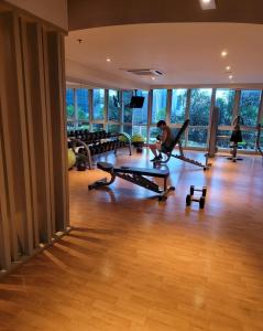 a room with a gym with a person exercising in a gym at Uptown Parksuites Tower 1 BGC - Staycations Up Above 12 Modern 1BR in Manila