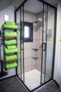 y baño con ducha y toallas verdes. en Bienvenue dans le chartreuse 2 à 6 couchages, en Cholonge