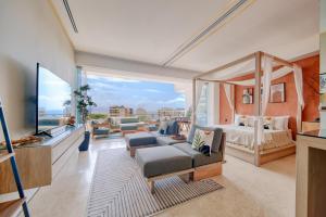 Una sala de estar con una cama y una gran ventana. en Maxwell Collection Romantic Zone, en Puerto Vallarta