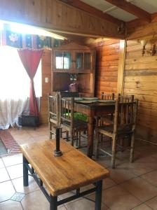 a dining room with a wooden table and chairs at Cabaña en Pichidangui un Oasis de naturaleza y relajación in Pichidangui