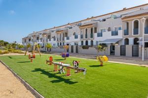 un parque infantil en un césped frente a un edificio en Luxury Town Apartment, en Los Lorcas
