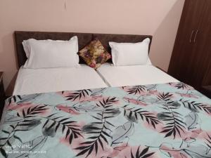 a bedroom with a bed with a floral comforter at Hotel vikram in Khajurāho