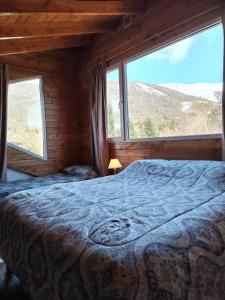 a bedroom with a bed and a large window at Catedral view mínimo 4 noches in San Carlos de Bariloche
