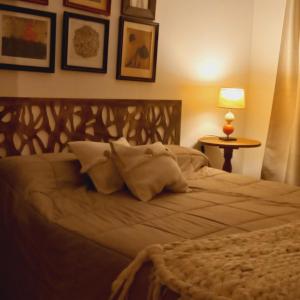 Un dormitorio con una cama grande con almohadas. en La Pausa, Departamentos y Casas en Chacras de Coria