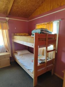 two bunk beds in a room with pink walls at Alma Patagona Hostel in Puerto Tranquilo