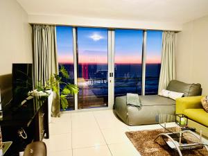 a living room with a couch and a large window at Sea&Mountain view by Caline VIP in Cape Town