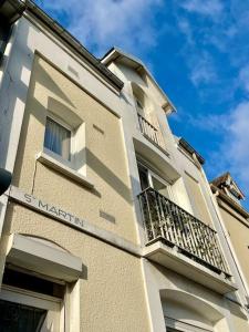 Un edificio con dos balcones a los lados. en Sigrid & Sea 2 étoiles, Fort-Mahon Plage, en Fort-Mahon-Plage