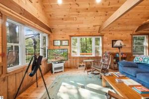 Cabaña de madera con sala de estar con sofá azul en Wildlife Haven Retreat, en Evart