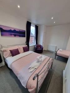 um quarto com uma cama grande e almofadas cor-de-rosa em Make yourself at home! 34AA em Headingley