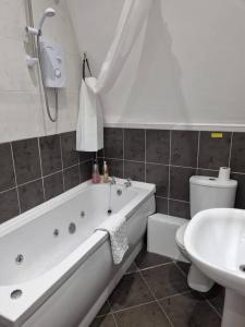 uma casa de banho com uma banheira, um WC e um lavatório. em Make yourself at home! 34AA em Headingley
