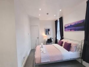 um quarto com uma cama com almofadas rosas e roxas em Make yourself at home! 34AA em Headingley