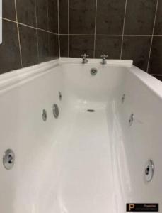 a white bath tub in a bathroom at Make yourself at home! Large Rooms, Comfy in Headingley