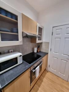 uma cozinha com uma porta branca e um micro-ondas em Make yourself at home! 34AA em Headingley