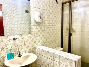 A 5 minutos del Aeropuerto el Dorado في بوغوتا: حمام مع حوض ومرآة ومرحاض