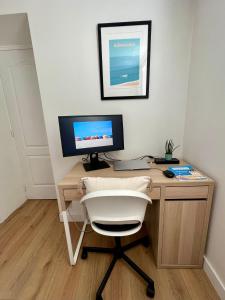 a desk with a computer monitor and a white chair at Pause Trouvillaise, 3 pièces centre ville, 45m² in Trouville-sur-Mer