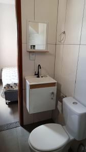 uma casa de banho com um WC, um lavatório e um espelho. em Hospedagem recanto do sábia flat 01 em Alto Caparaó