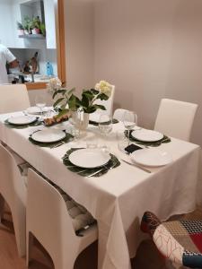 - une table blanche avec des assiettes et des verres dans l'établissement VUT PORTONOVO 2 DORMITORIOS, à Portonovo