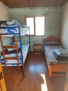 a room with two bunk beds and a window at Alma Patagona Hostel in Puerto Tranquilo