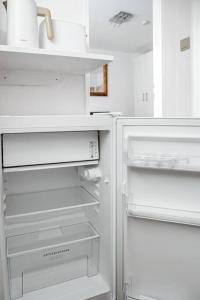 una nevera blanca con la puerta abierta en una cocina en Wiesbaden - Apartment im Nerotal, en Wiesbaden