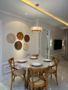 uma sala de jantar com uma mesa branca e cadeiras em Flat Beira Mar em Fortaleza
