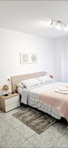 a white bedroom with a bed and a rug at Apartamento Casa Tambo, Campelo in Pontevedra