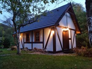 una pequeña casa con techo de gambrel con luces encendidas en Górski Sad - Bazylia, en Piechowice