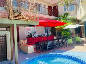 eine Terrasse mit einem Tisch, Stühlen und einem Pool in der Unterkunft HOTEL PRIMAVERA BOUTIQUE in San Pedro Sula