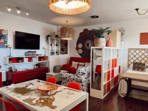 een woonkamer met een tafel en rode stoelen bij Lovely Suite Miramar in Málaga