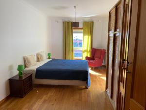 1 dormitorio con 1 cama, 1 silla y 1 ventana en Apartamento novo muito confortável com vista Rio en Algés