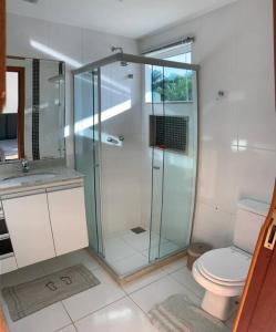 uma casa de banho com uma cabina de duche em vidro e um WC. em Geriba casa do canto- 2 minutos da praia a pé em Búzios