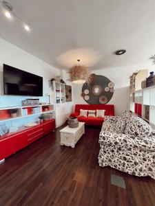 een woonkamer met een rode bank en een tv bij Lovely Suite Miramar in Málaga