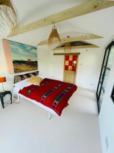 a bedroom with a bed with a red blanket at High spec studio cabin-Farnham centre in Farnham