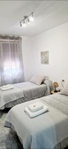 Habitación con 2 camas y mesa con bandeja. en Apartamento Casa Tambo, Campelo, en Pontevedra