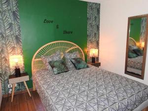 1 dormitorio con cama y pared verde en Suite Cosy&Jacuzzi, en Cenon