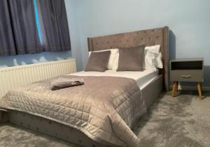 a bedroom with a bed and a night stand at Cheshunt Hertfordshire 4 bed in Cheshunt