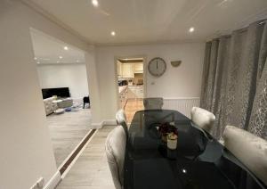 a living room with a table and chairs and a clock at Cheshunt Hertfordshire 4 bed in Cheshunt