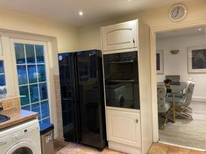 a kitchen with a black refrigerator and a table at Cheshunt Hertfordshire 4 bed in Cheshunt