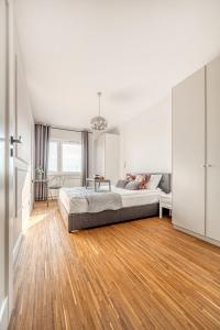 a bedroom with a bed and a wooden floor at Manufaktura Business Suites - Parking, Balcony, Nature View, Shopping Nearby, Fast Internet - by Rentujemy in Łódź