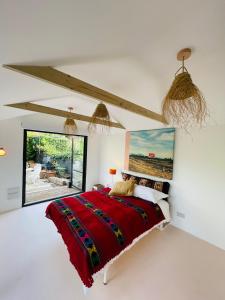 a bedroom with a red bed and a window at High spec studio cabin-Farnham centre in Farnham