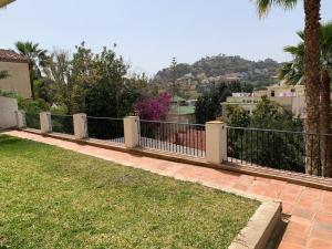 een hek voor een tuin met gras bij Lovely Suite Miramar in Málaga