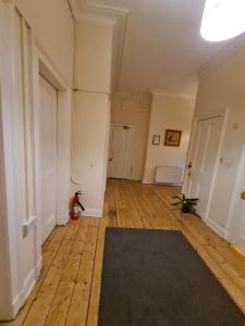 een lege kamer met een tapijt op een houten vloer bij Haymarket Station Rooms in Edinburgh