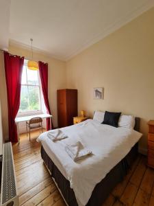 Un dormitorio con una cama grande y una ventana en Haymarket Station Rooms, en Edimburgo